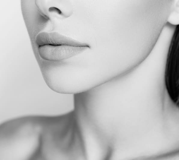 Profile side view cropped close up photo of dreamy sweet well-groomed lady with her naked shoulder she isolated on pastel beige background stand half turn to camera focus on lips (Profile side view cropped close up photo of dreamy sweet well-groomed l
